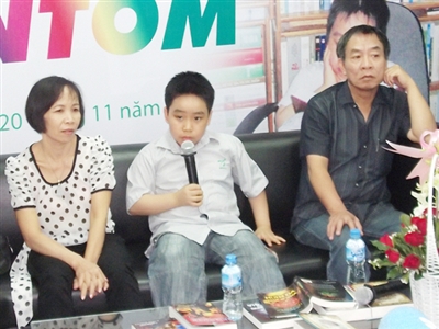 Cây bút nhí Nguyễn Bình (ngồi giữa) cùng bố mẹ tại buổi giao lưu với bạn đọc .  
